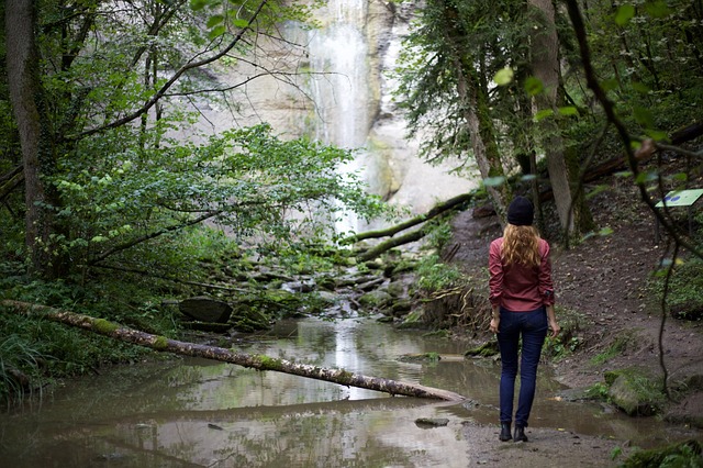 Junge Frau als Wanderin am Wasserfall