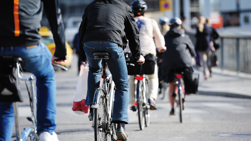 FAhrradfahrer auf einer Straße von hinten zu sehen.