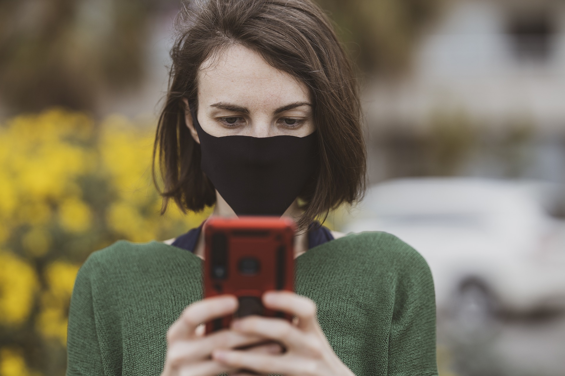 Frau mit Maske und Smartphone