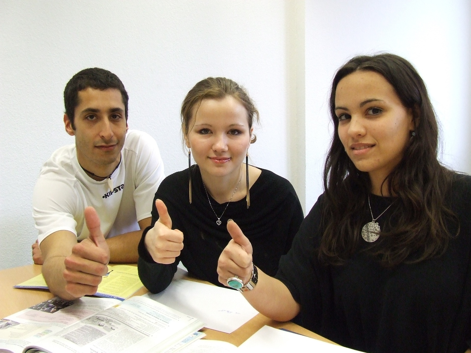 Drei junge Menschen mit Daumen hoch