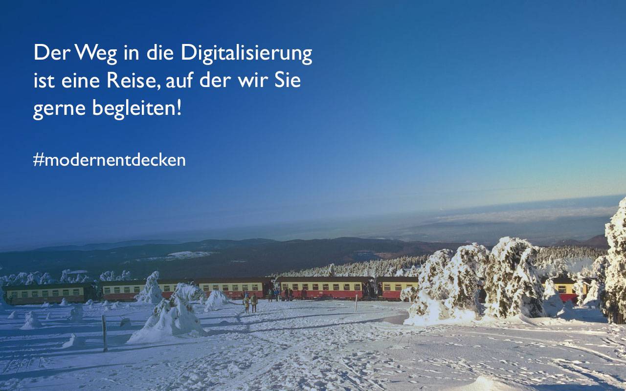 Touristen beobachten die Harzer Schmalspurbahn auf dem Weg zum Brocken im Schnee. Text: Der Weg in die Digitalisierung ist eine Reise, auf der wir Sie gerne begleiten! #modernentdecken