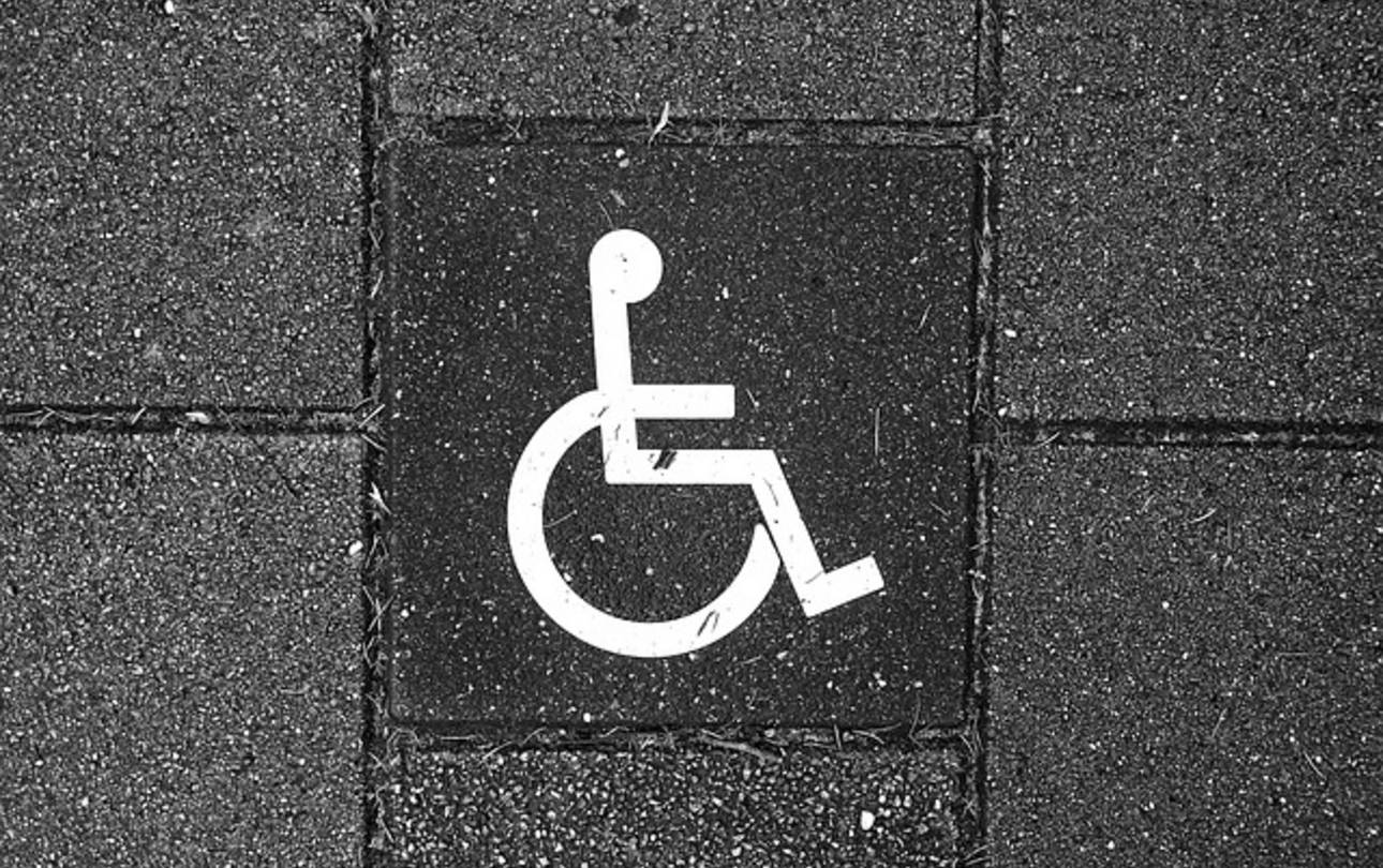 Ausschnitt eines Gewegs aus Betonsteinen mit weißem Rollstuhlpiktogramm ©MableAmber, pixabay