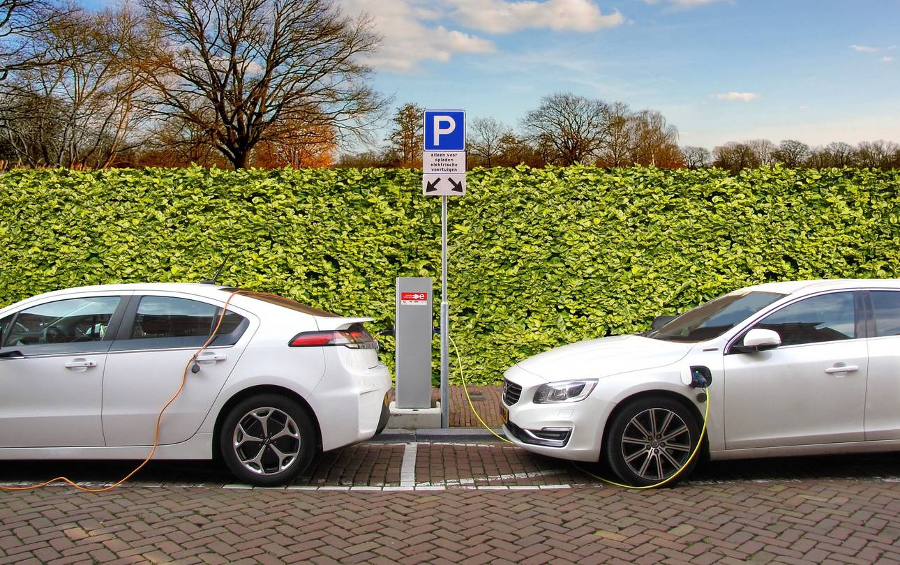 2 weiße Elektroautos an der E-Ladestation