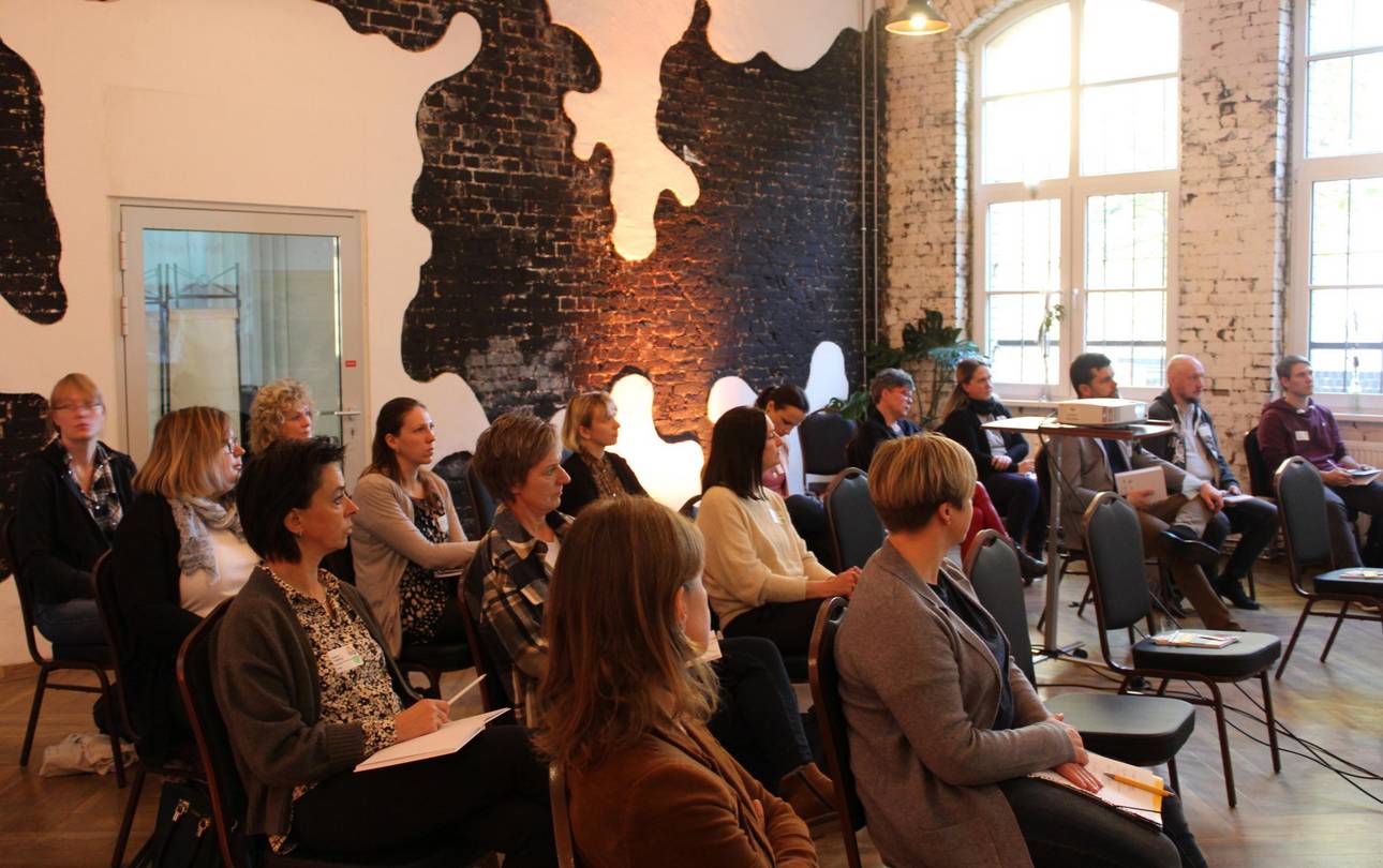 Teilnehmer*innen sitzen im Präsentationsraum