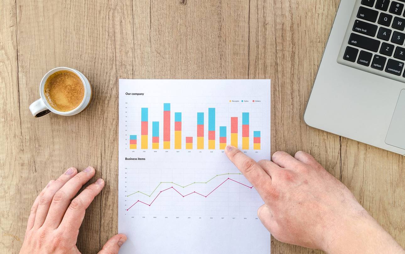 Mensch zeigt mit Finger auf Blatt Papier