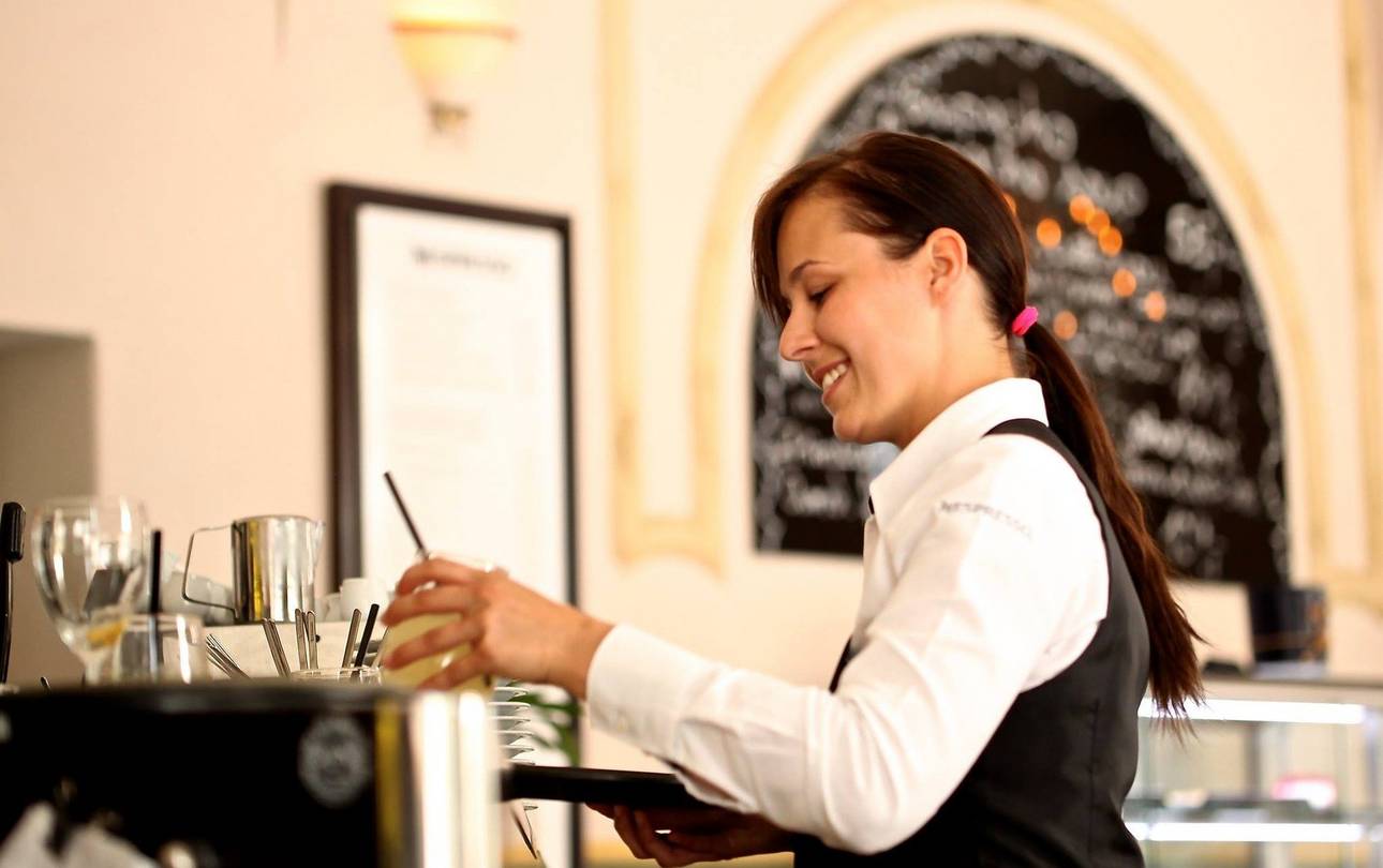 Kellnerin an Kaffeeautomat