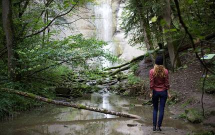 Junge Frau als Wanderin am Wasserfall