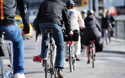 Fahrradfahrer FAhrradfahrer auf einer Straße von hinten zu sehen.