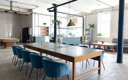Nudelfabrik von Innen als großer Gemeinschaftsraum mit Tisch in der Mitte und Küche