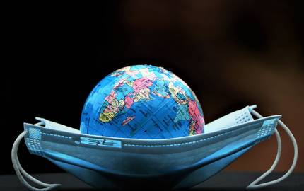 Zehn Prozent der Corona-Infektionen erfolgen im Ausland Erdball und Mundschutz