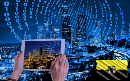 Unternehmen als Vorbild für die Digitalisierung Damenhände halten ein Tablet, welches ein Foto der Binärcodes eines Stadt macht; rechts unten die Flagge und das Wappen von Sachsen-Anhalt