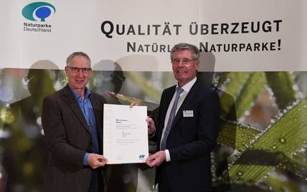 Geschäftsstellenleiter Dr. Klaus George nahm die Urkunde aus den Händen des Präsidenten des Verbandes Deutscher Naturparke Friedel Heuwinkel entgegen.