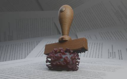 Stempel zerdrückt Coronavirus auf Papier