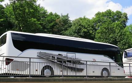 Save the Date: Neue Normalität - zurück in die Zukunft! Tag der Bustouristik am 10. Januar 2022 in Wiesbaden Reisebus hinter Geländer, Wald im Hintergrund