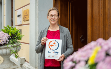 Hotelinhaberin mit Bett Bike-Schild