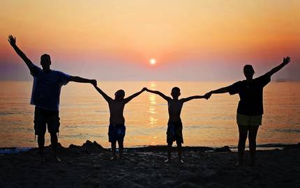 Familie am Strand vor Sonnenuntergang