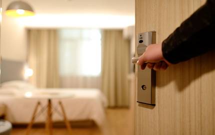 Mann öffnet Tür zu Hotelzimmer