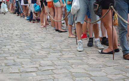 Beine von Menschen in Wartschlange