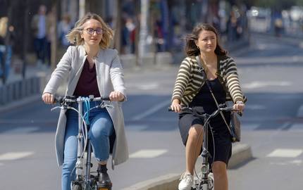 2 Frauen mit Fahrrad in einer Stadt