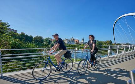 Radfahrer in Dessau auf der Tiergartenbrücke an der Mulde
