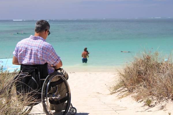 Mann im Rollstuhl am Strand