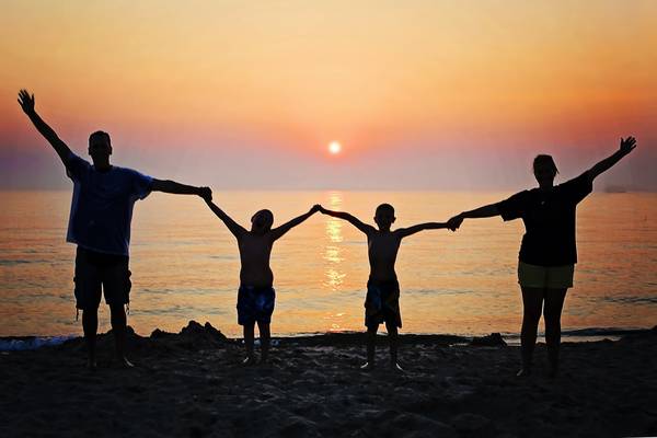 Familie am Strand mit Sonnenuntergang