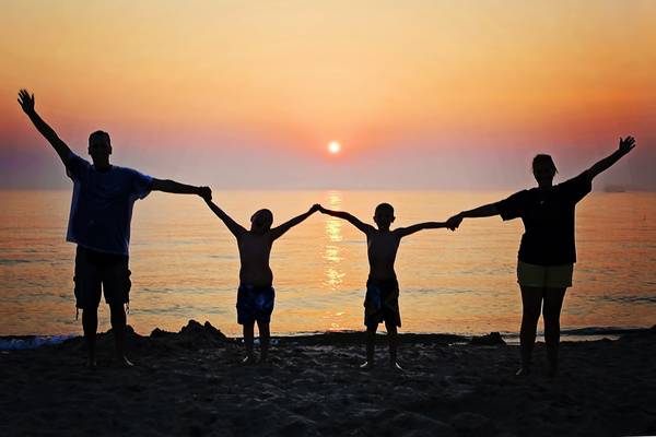 Familie am Strand vor Sonnenuntergang