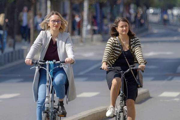 2 Frauen mit Fahrrad in einer Stadt